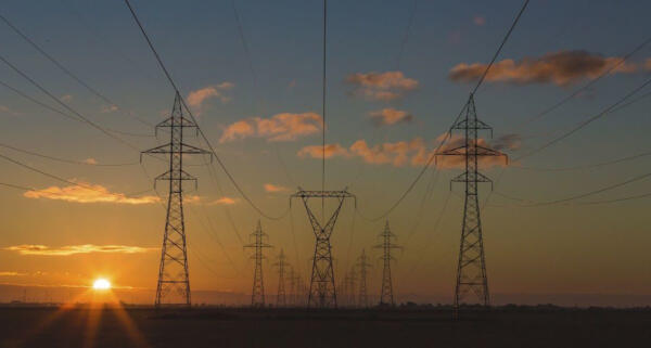 Electricity pylons at sunrise OR sunset, unidentified location. Original public domain image from Wikimedia Commons
